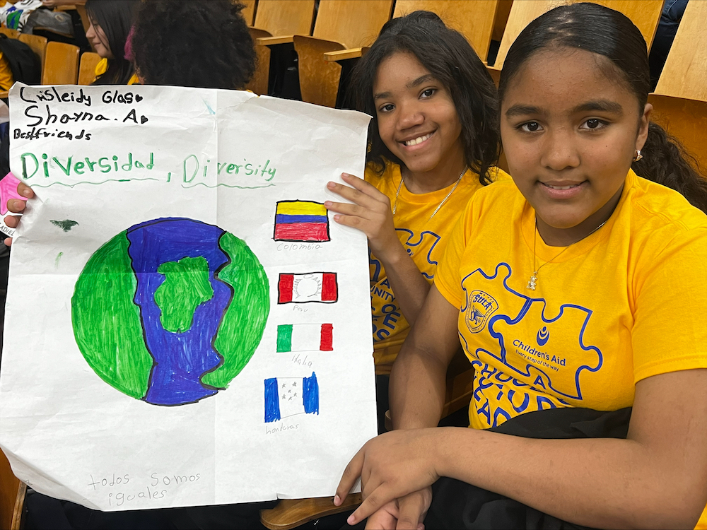 Students from Salomé Ureña Leadership Academy holding a poster